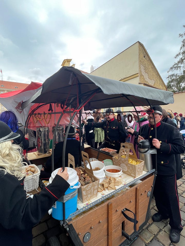 Masopust celebrants in traditional masks and costumes parading through the streets of Prague.