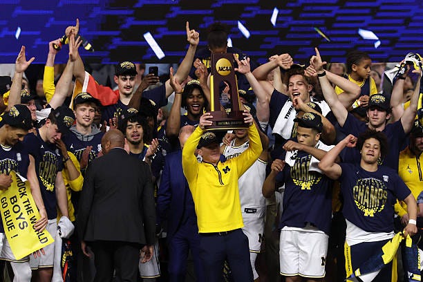 Head coach Dusty May of the Michigan Wolverines hoists the trophy after defeating the UConn Huskies 69-63 in the National Championship of the 2026...