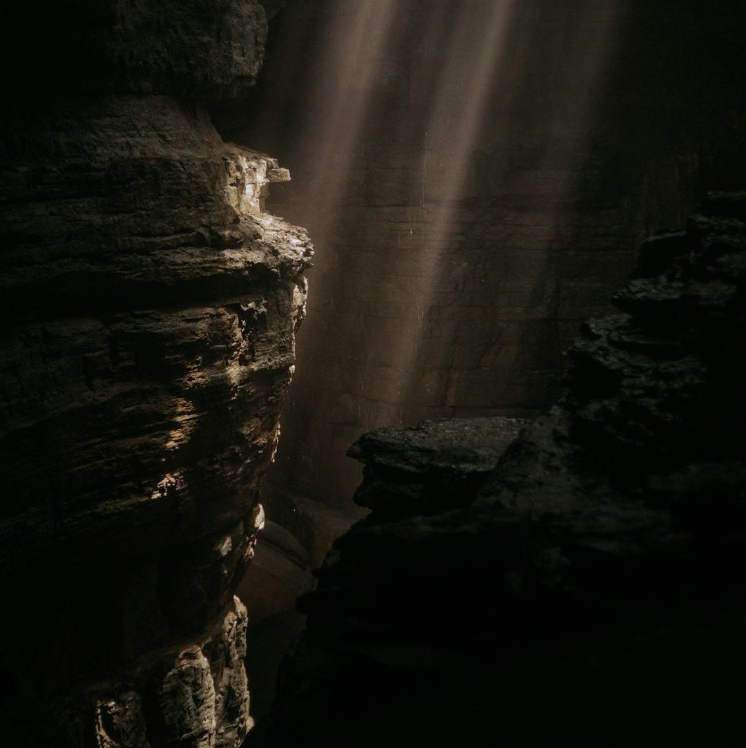 a light shines through a crack in the rocks