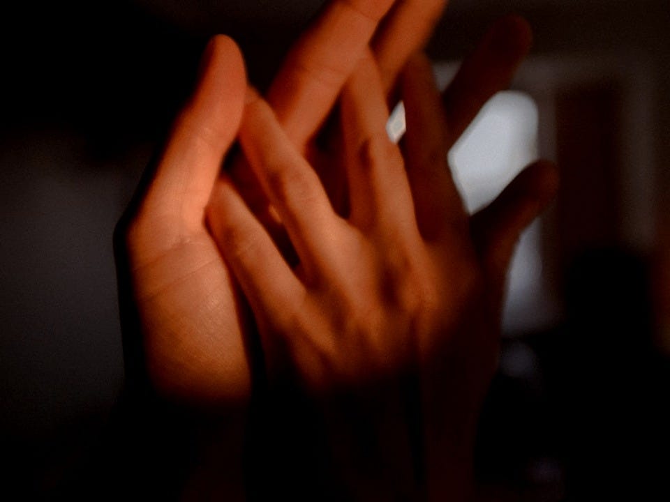 persons left hand on dark room