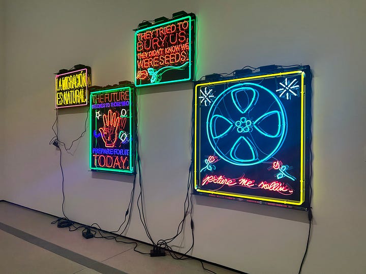 Andy Warhol's soup cans, Jeff Koons' Balloon Dog (Blue), neon lights with various phrases on them, such as "they tried to bury us but they didn't know we were seeds," and Hannah in the Infinity Room