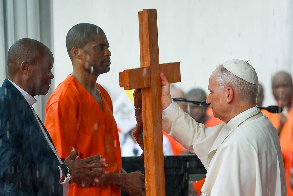 Pope Leo XIV receives a cross from an inmate at Bata prison