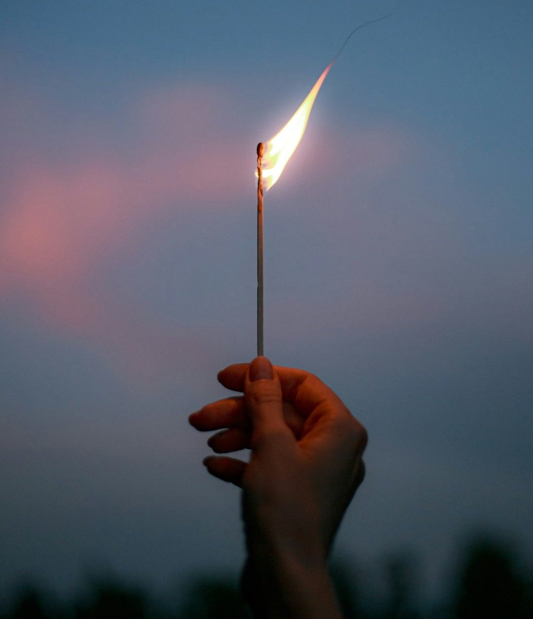 person holding lighted match stick person holding lighted match stick