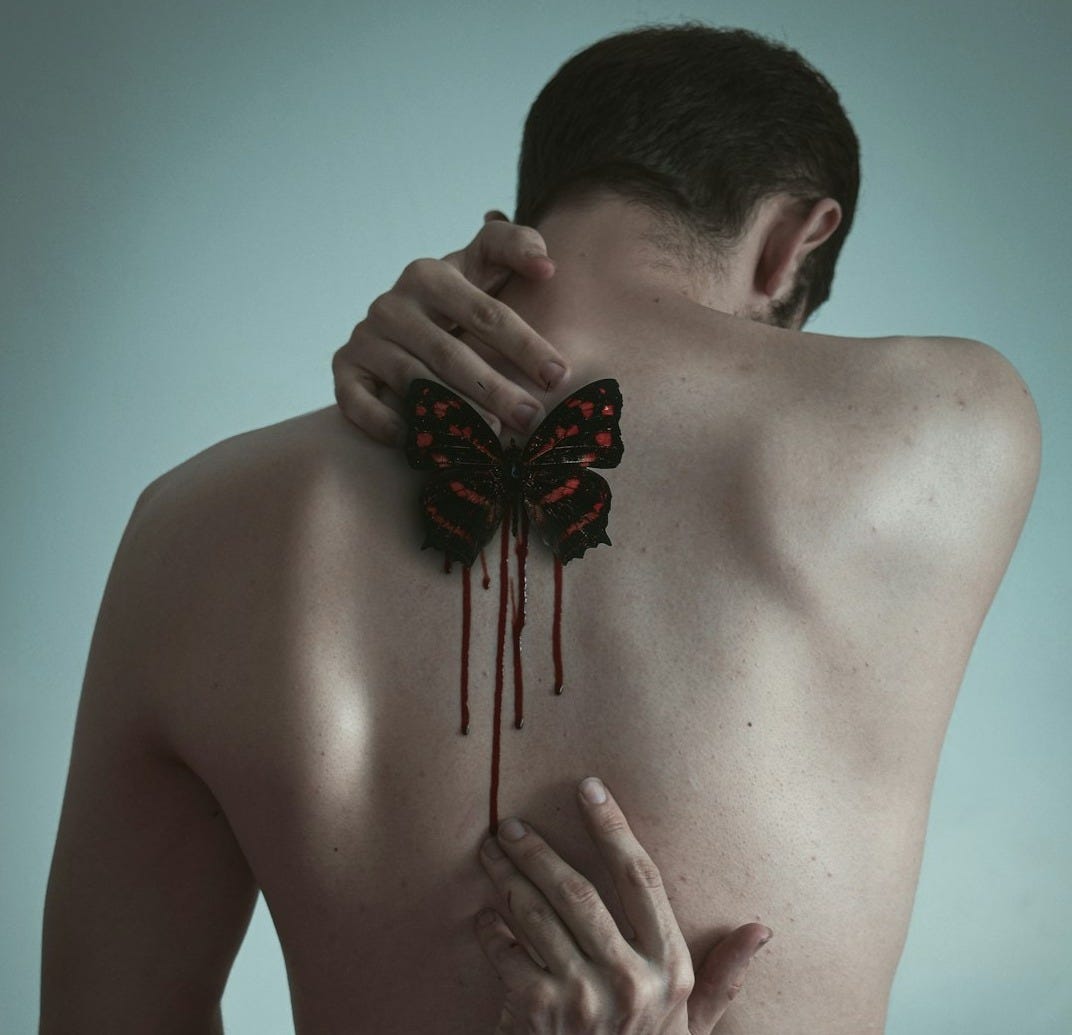 topless man with black and red flower on his face
