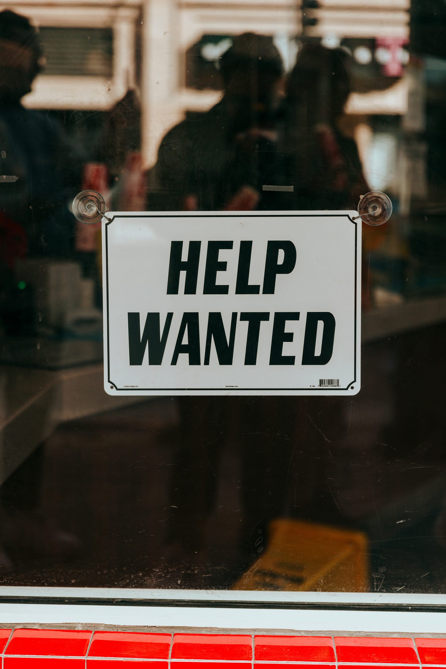 Help Wanted sign in storefront window - Ontario job posting law exemption for general hiring signs