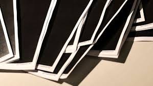 Documents released from Jeffrey Epstein, including a sheaf of entirely redacted pages, are seen in this handout released by the US Justice Department and printed and arranged for a photograph by Reuters in Washington, DC, on December 19.