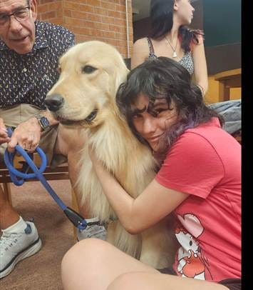 A person sitting with a dog

AI-generated content may be incorrect.