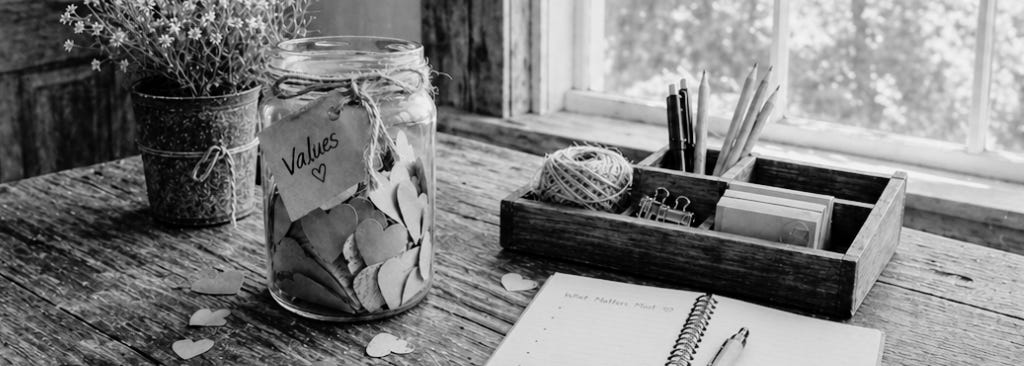 A jar of paper hearts with a paper tag tied to it that says, "values".