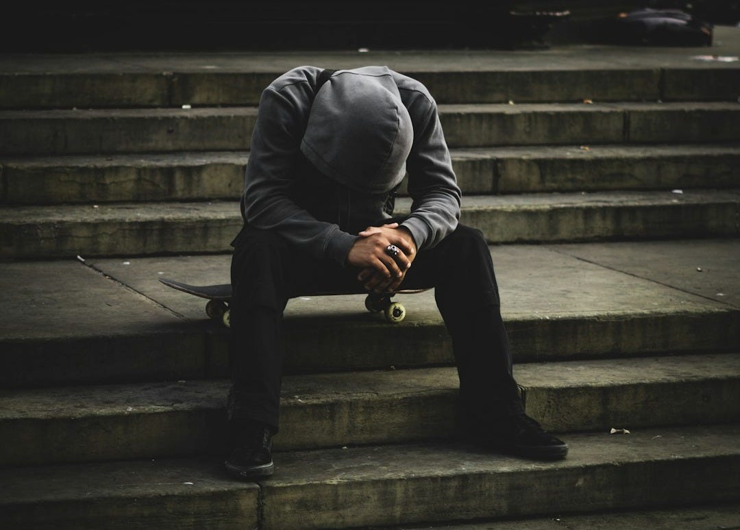 a man sitting on some steps with his head in his hands