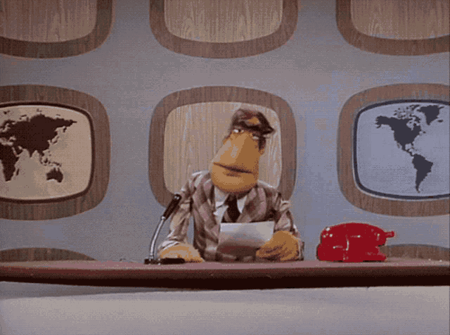 a cartoon character is sitting at a desk with a microphone and a red telephone a cartoon character is sitting at a desk with a microphone and a red telephone