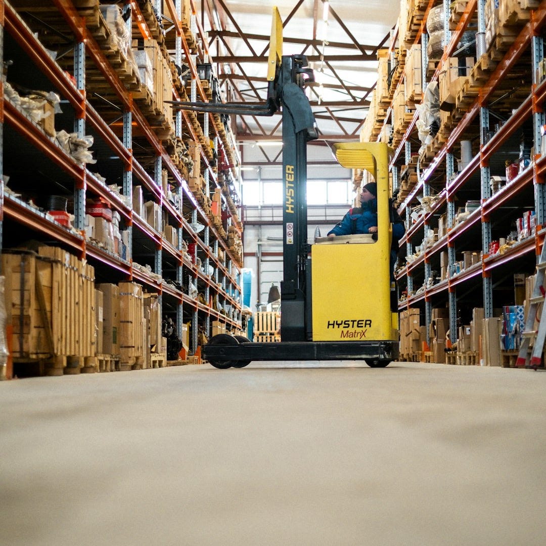 A yellow forklift in a large warehouse A yellow forklift in a large warehouse