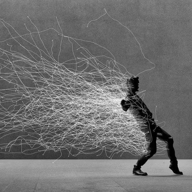 This may contain: a black and white photo of a man running with wires in the air behind him