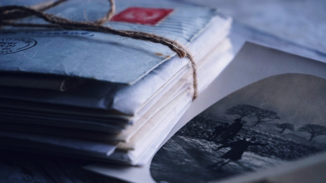 Free A close-up of vintage letters tied with twine alongside an old black and white photograph. Stock Photo