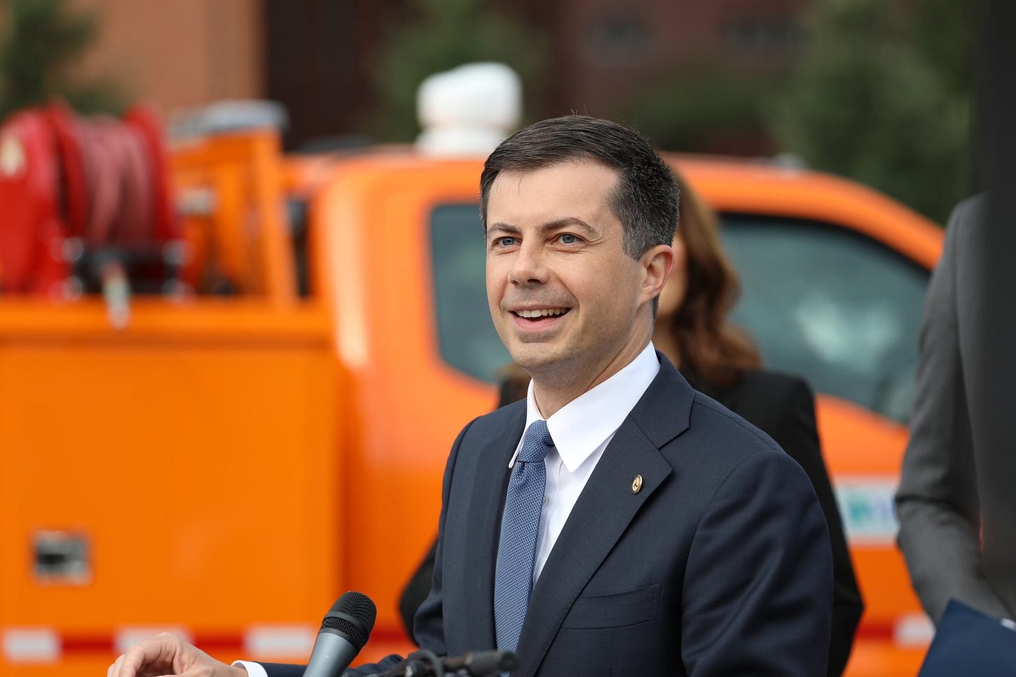 Secretary Pete smiling as he gives remarks in Detroit, MI to celebrate their INFRA grant.