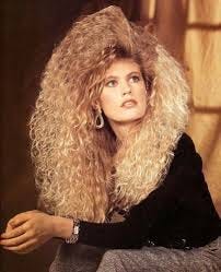 woman with gigantic crimped hair in the 80s, seriously, words don't do it justice, i'm sorry. it's like a lion mane, but more. A glowing halo around her head, a crimped ruff...