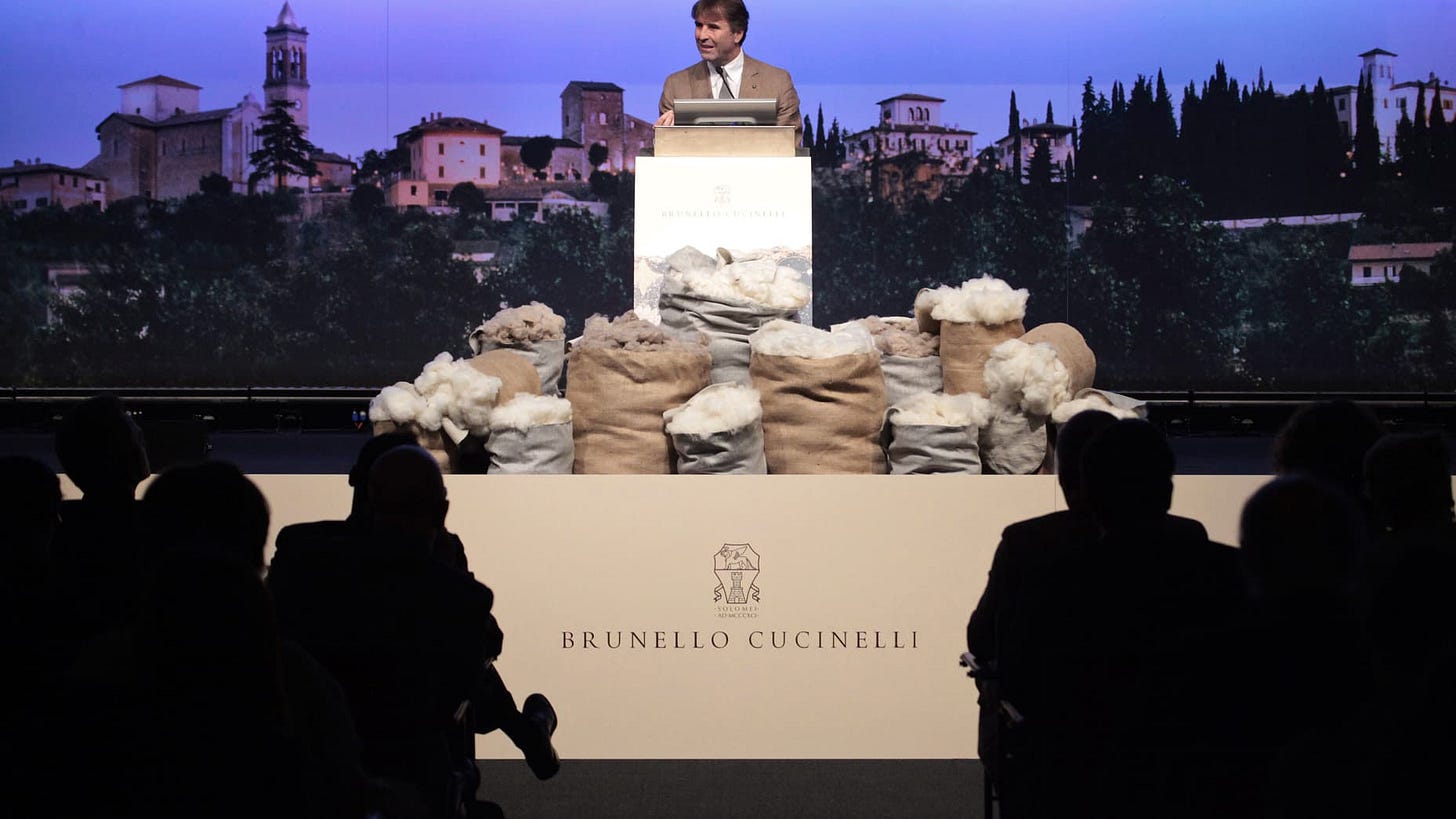 Brunello Cucinelli, chairman and chief executive officer of Brunello Cucinelli SpA, center, speaks during a news conference to announce the company's initial public offering (IPO), inside the Borsa Italiana, Italy's Stock Exchange in Milan, Italy, on Friday, April 27, 2012. Brunello Cucinelli SpA, an Italian maker of luxury cashmere clothing, rose 37 percent on its debut in Milan trading after investors sought to purchase 17 times the amount of stock available in an initial public offering. Photographer: Mi