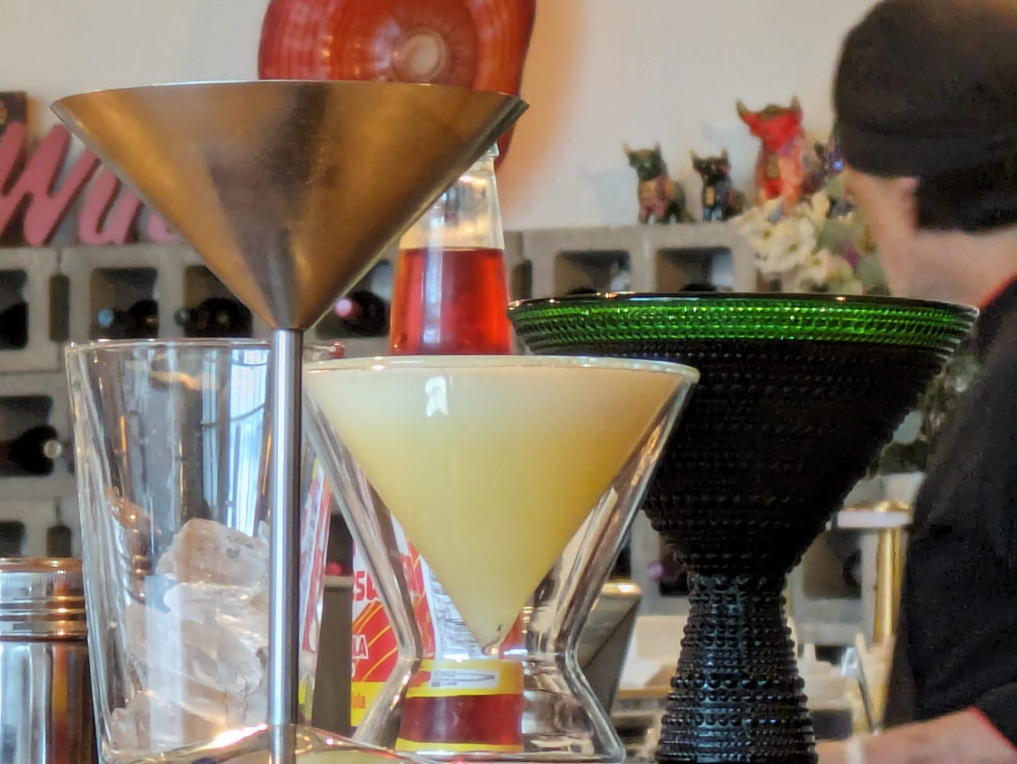 Three triangular cocktail glasses of different colors at Panka