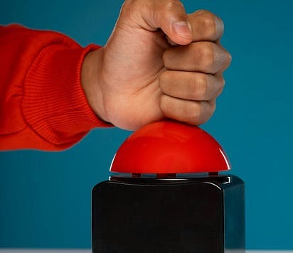 Hand pressing a large red button