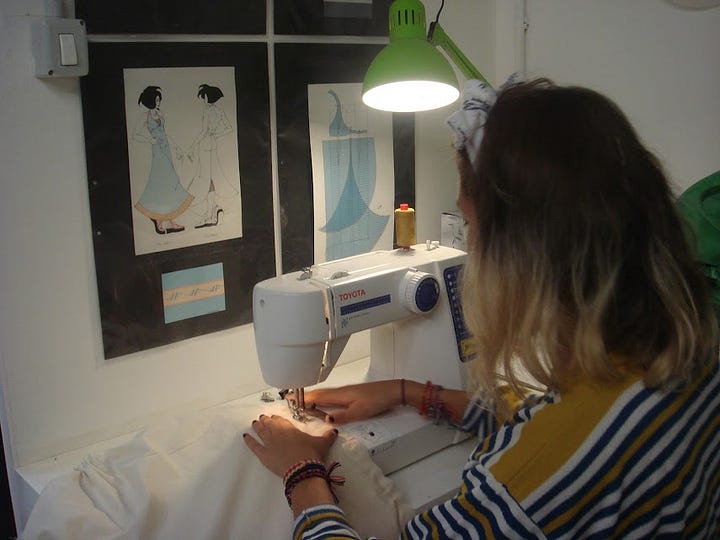 1) Lila Sky de espaldas, frente a una máquina de cose y bajo una lámpara, mientras confecciona. 2) Lila Sky y su maestra de diseño de modas en el taller de la Accademia D'Arte AD'A