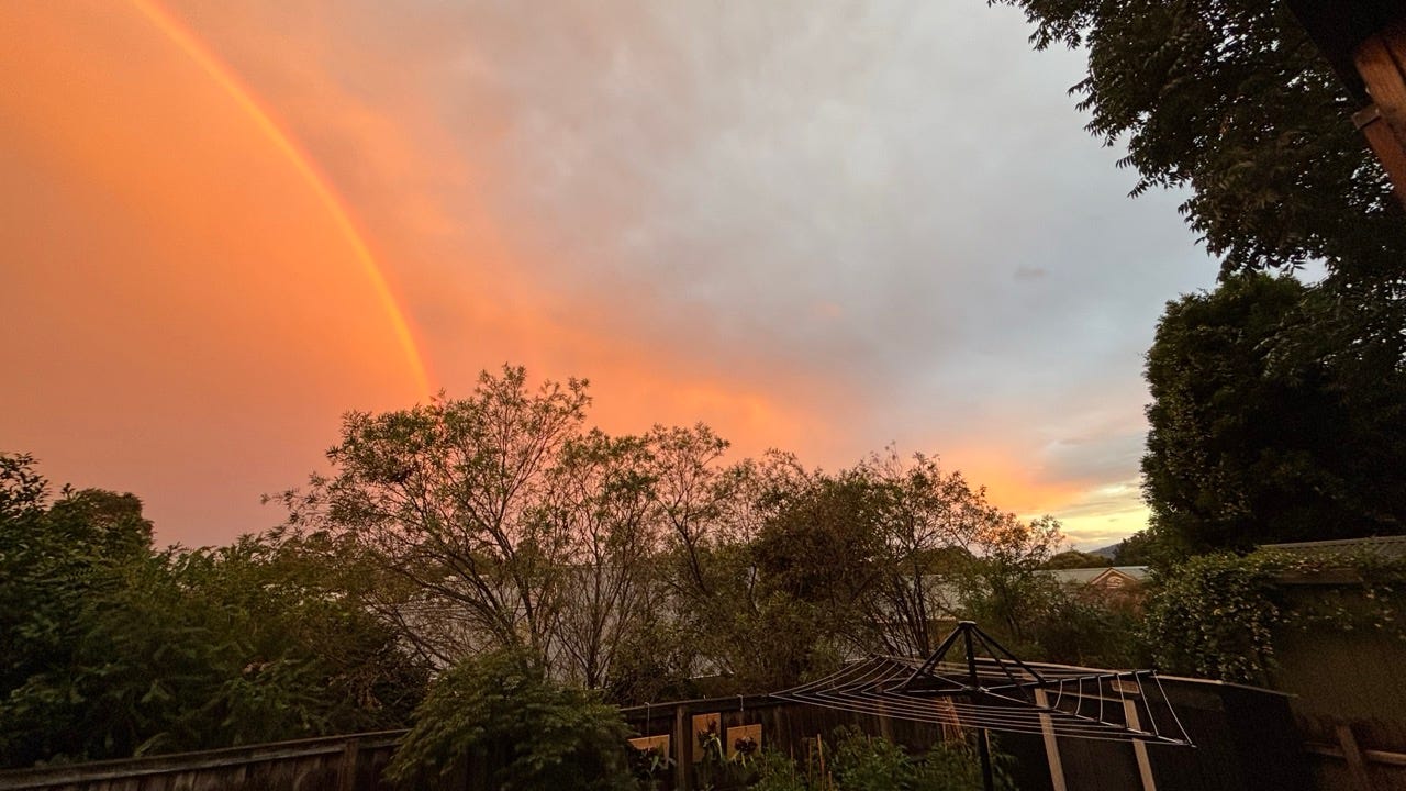 Bright orange rainbow in a grey cloudy sky