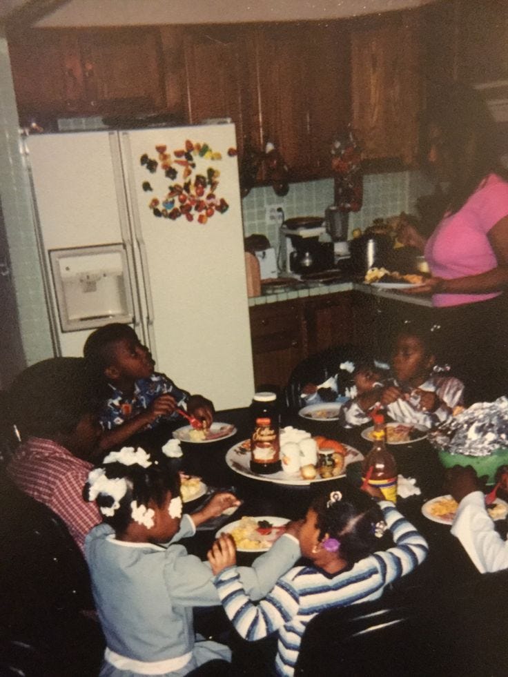 This may contain: a group of children sitting around a kitchen table eating cake and other food on plates