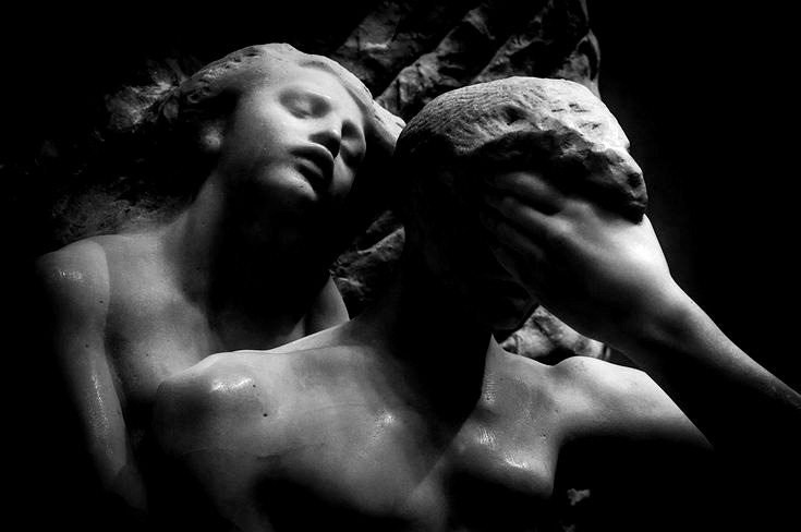 This may contain: two statues are shown with one holding the other's head