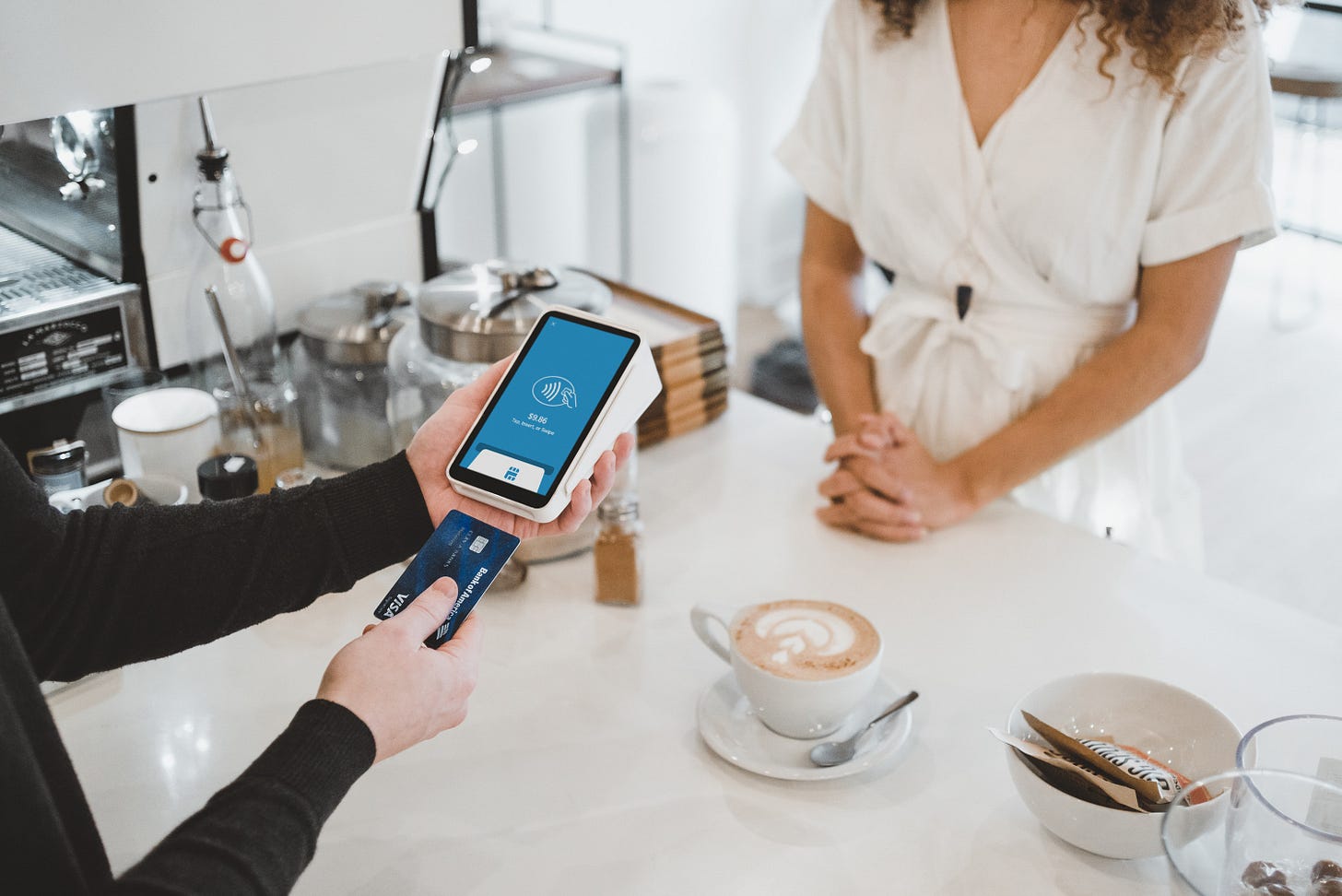 Image of a credit card terminal being used during the check out process at a cafe Image of a credit card terminal being used during the check out process at a cafe