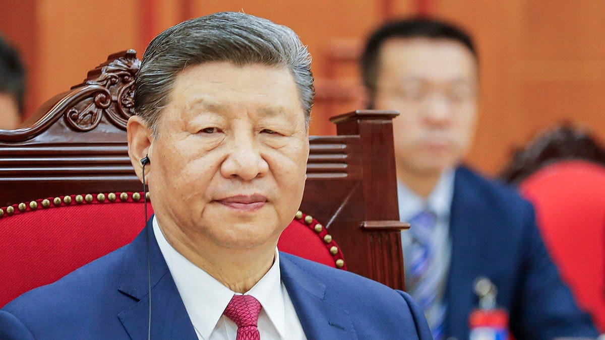 Xi Jinping with an ear piece in listening during a meeting