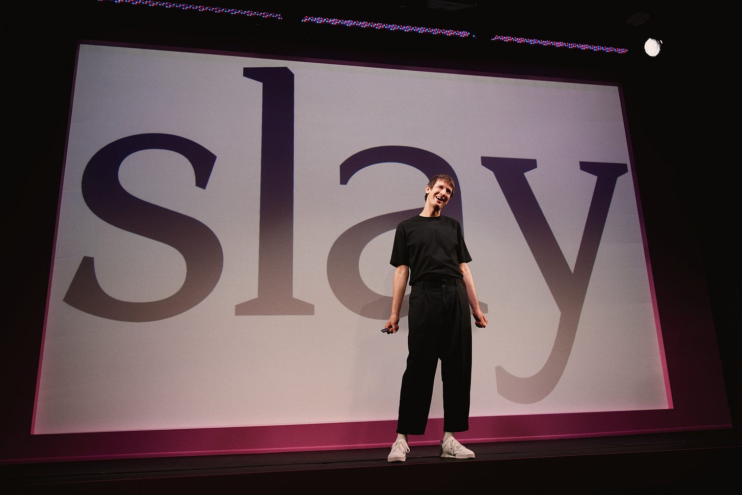 Josh Sharp stands in front of a slide that reads "slay" in gigantic letters Josh Sharp stands in front of a slide that reads "slay" in gigantic letters