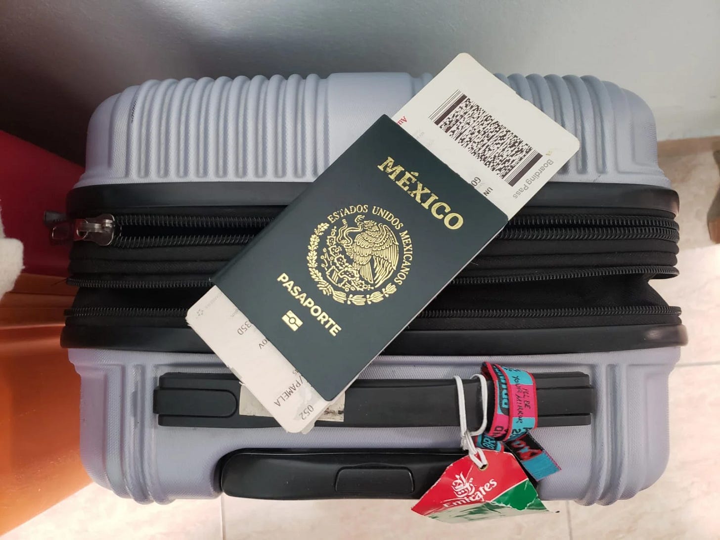 pasaporte mexicano sobre una maleta de carry on