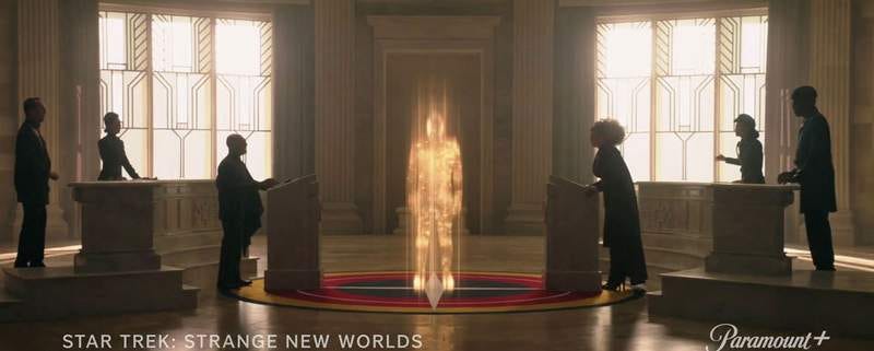 Scene from "Star Trek: Strange New Worlds" showing Captain Pike beaming into a room full of people.