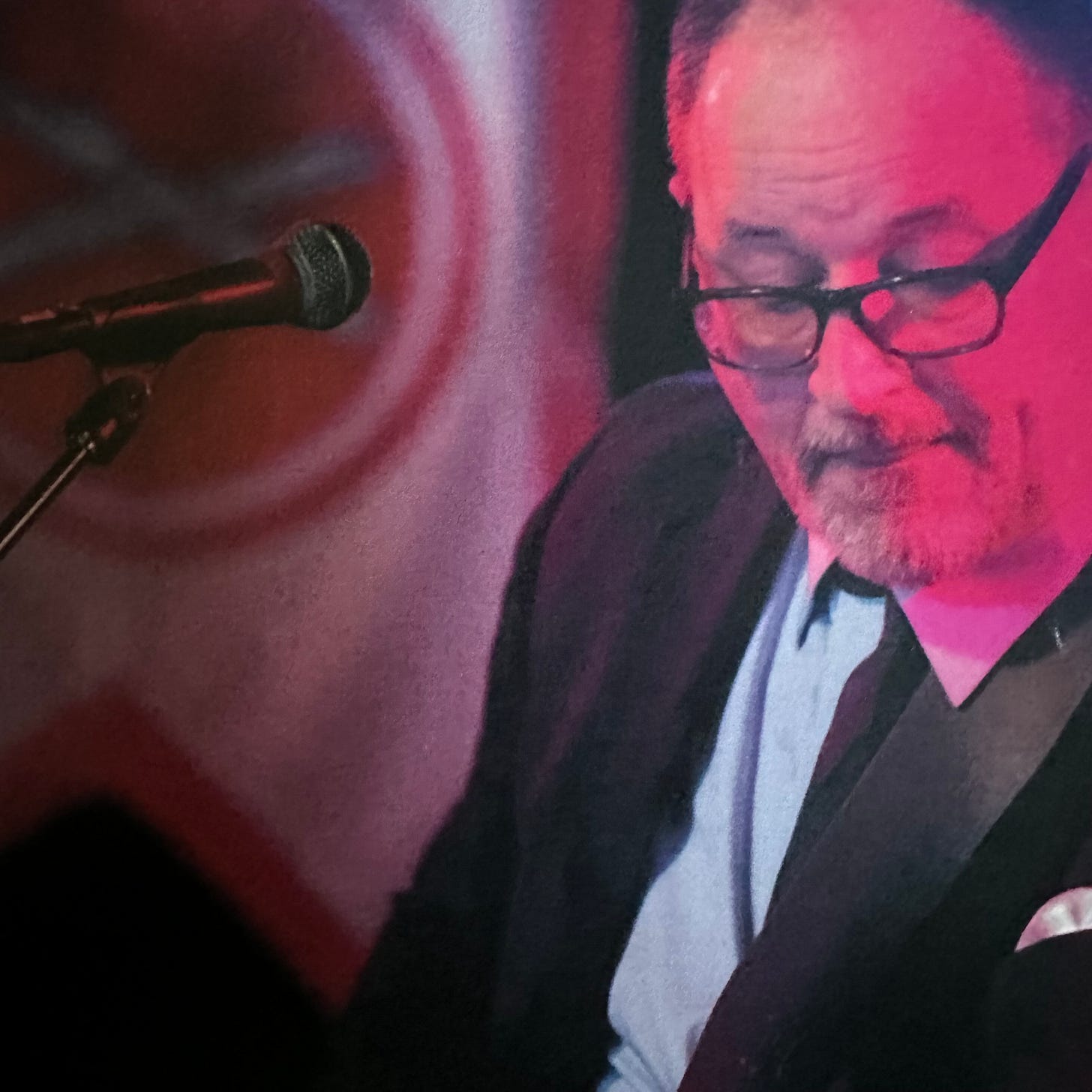 Man in a suit, playing music on a guitar