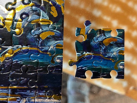a jigsaw of the vincent van gogh painting starry starry night in various levels of completion. the final photo shows the four duplicate pieces included next to where they matched the puzzle.