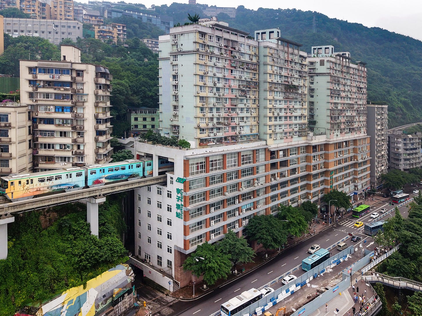 A train of Chongqing Rail Transit Line 2 coming through a residential building at Liziba A train of Chongqing Rail Transit Line 2 coming through a residential building at Liziba
