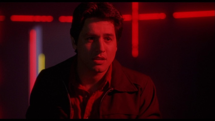 Robert Beltran as Hector in a nightclub bathed in red neon lighting in Night of the Comet (1984).
