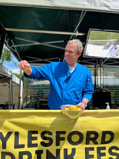 Three images of a man dressed in a blue shirt at a food festival standing on a stage squeezing a lemon