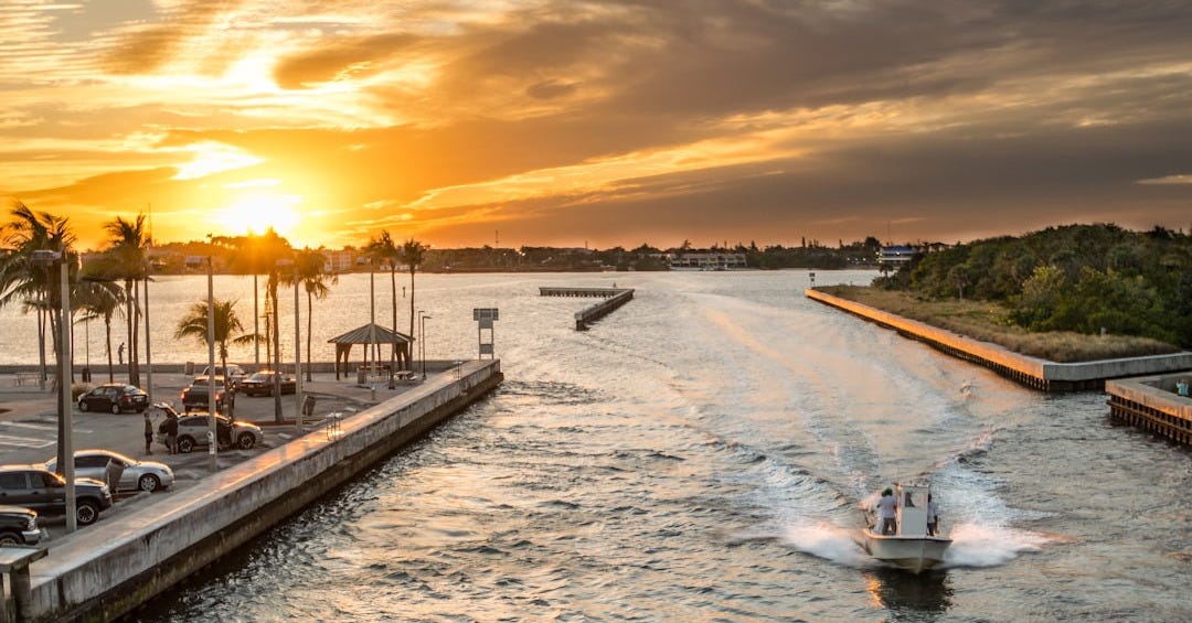 people sailing on river near parking lot