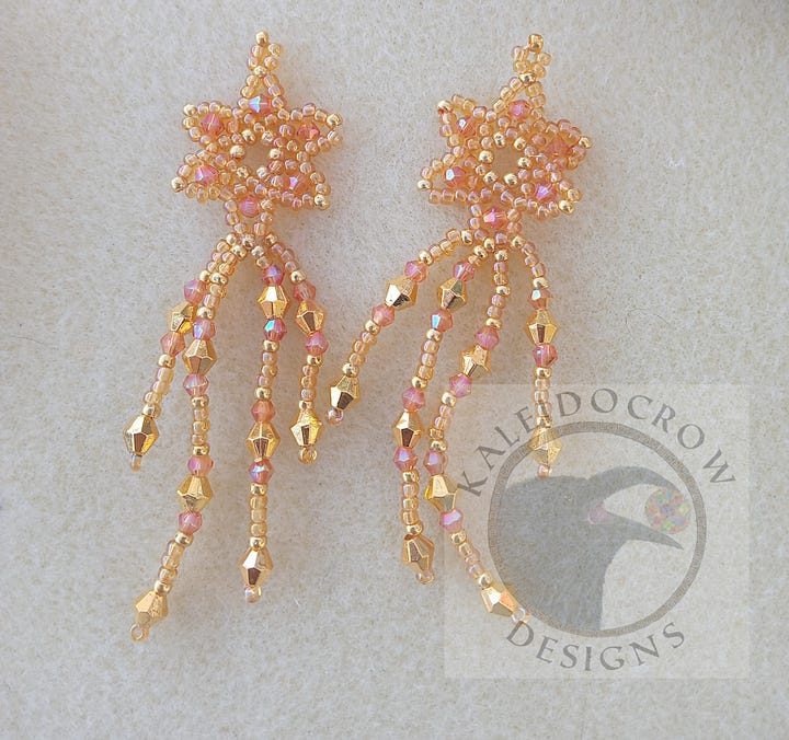 Sparkly dangly beaded earrings in a peach/gold color and a green/gold color.