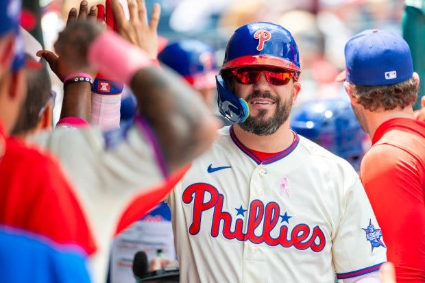 Phillies' Kyle Schwarber is congratulated in the dugout after hitting a solo home run in the first inning against the Colorado Rockies on Sunday at Citizens Bank Park in Philadelphia. (AP Photo/Laurence Kesterson)
