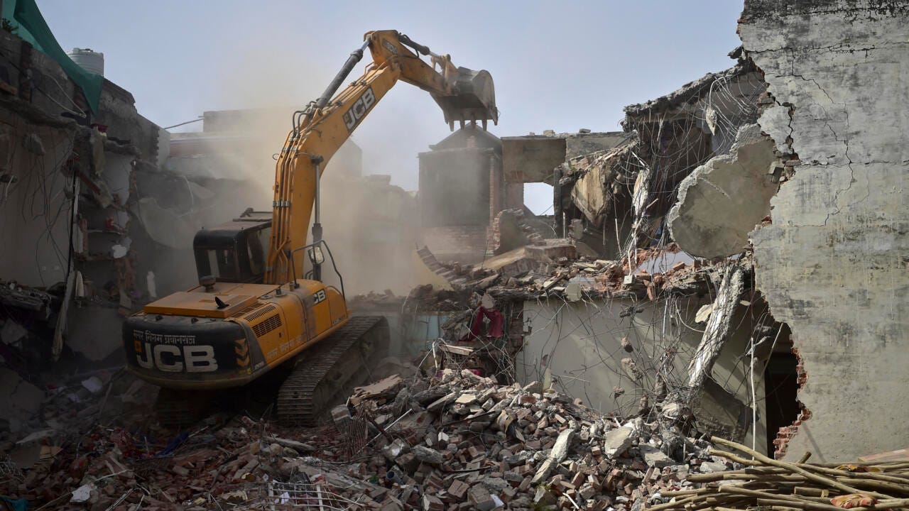 A bulldozer demolishes Javed Mohammad's house in Allahabad, India on June 12, 2022.
