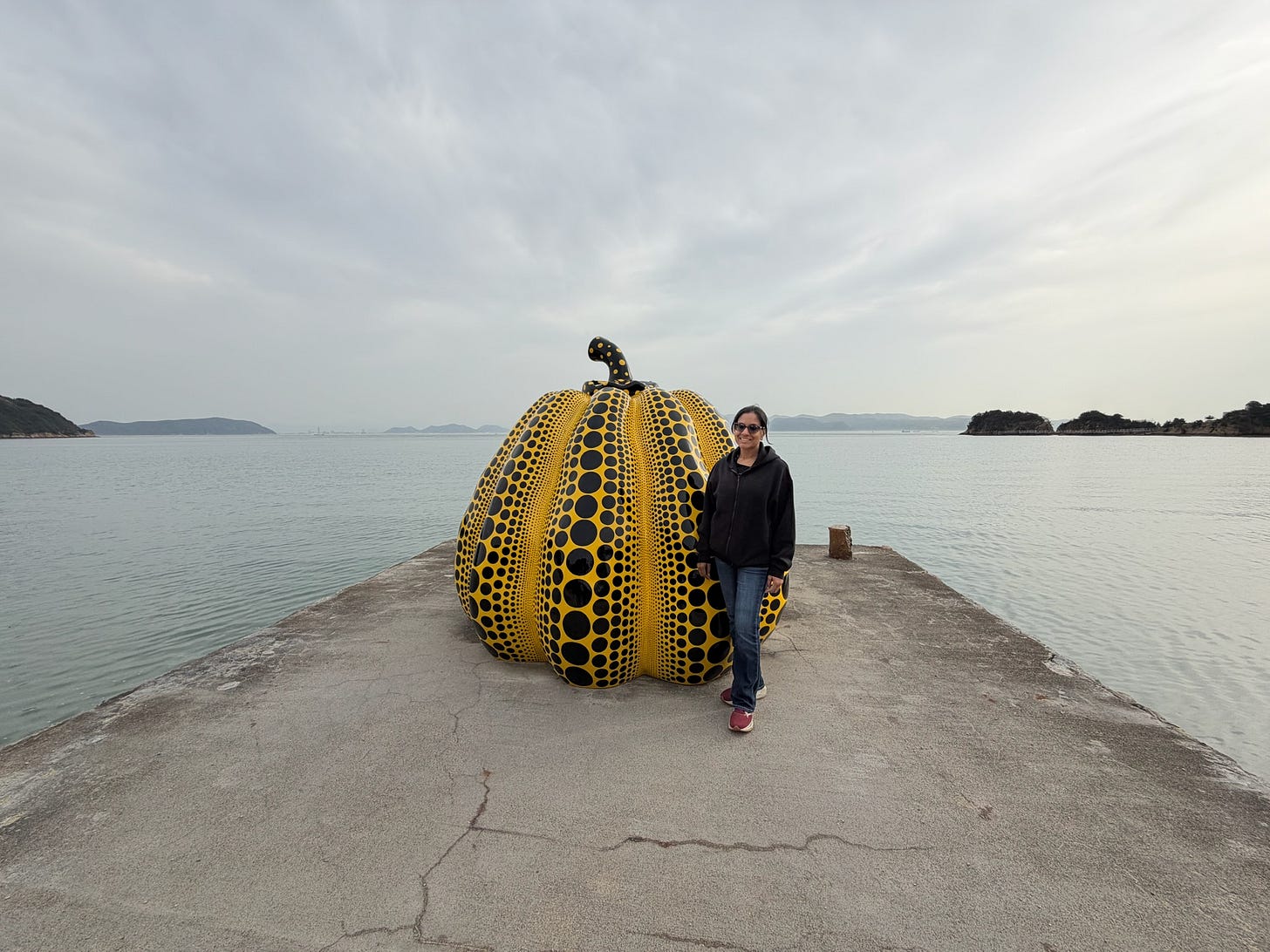 Author standing with Kusama's yello "Pumpkin," in Naoshima.