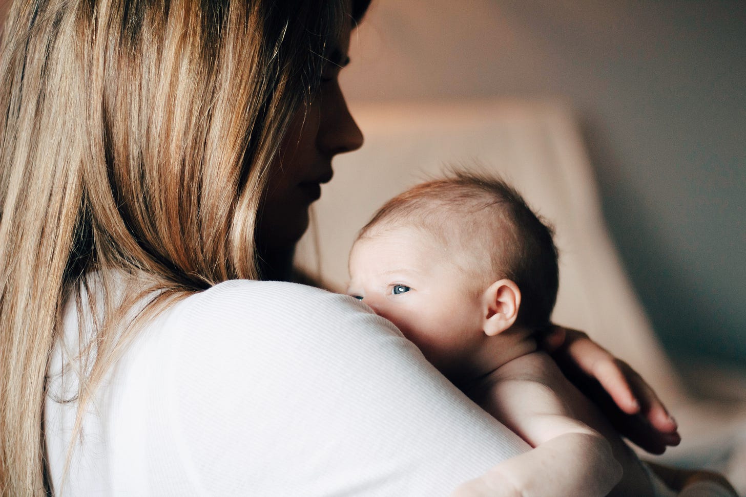 Profile of a young white mom with a very tiny new baby Profile of a young white mom with a very tiny new baby