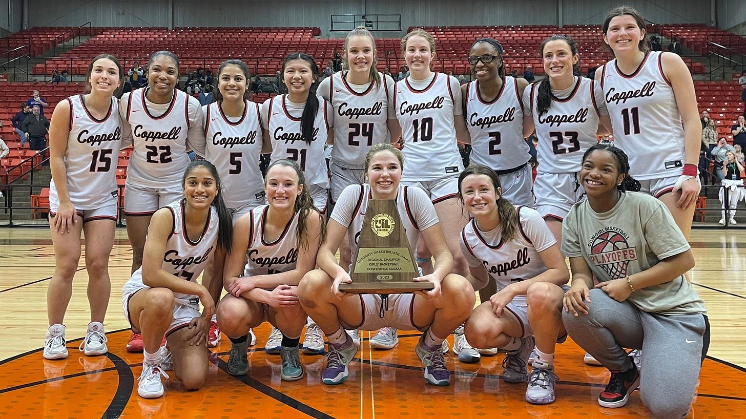High school girls basketball team posing with a trophy