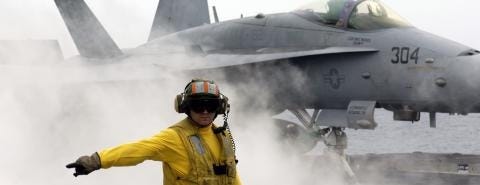 A sailor prepares to launch an F/A-18C Hornet off the flight deck of the USS Kitty Hawk in the Philippine Sea on May 6, 2008. (US Navy)