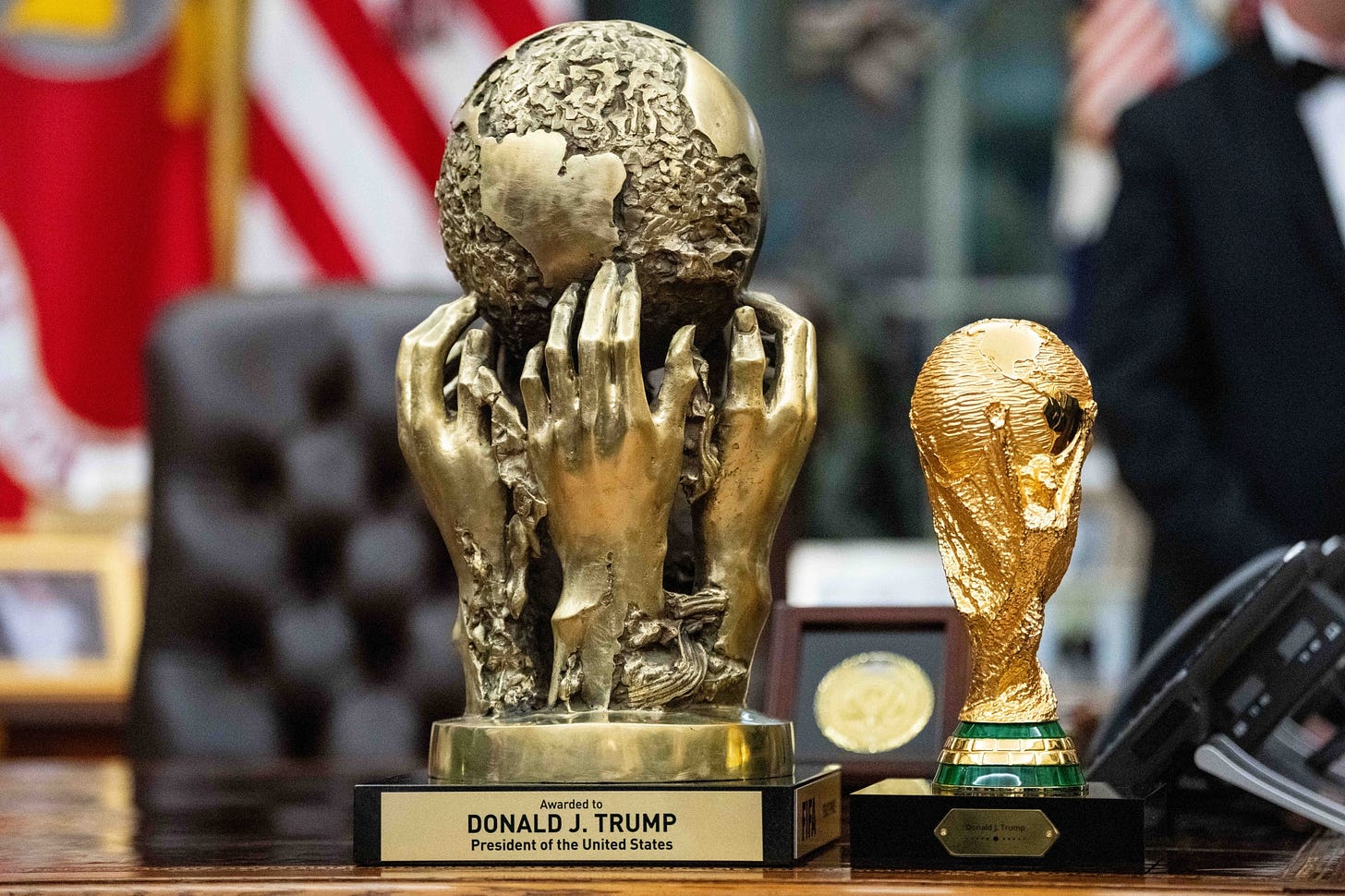 The Football Association (FIFA) Peace Prize, presented to US President Donald Trump at the 2025 World Cup Draw, left, displayed next to the FIFA World Cup Trophy during the Kennedy Center Honors medal presentation ceremony in the Oval Office of the White House in Washington, DC, US, on Saturday, Dec. 6, 2025. The 2025 recipients of the Kennedy Center Honors include actor Sylvester Stallone, rock band Kiss, singer Gloria Gaynor, country music icon George Strait, and the English theater actor Michael Crawford. Photographer: Bonnie Cash&#x2F;UPI&#x2F;Bloomberg