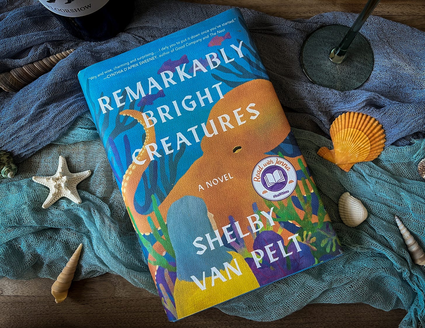 Remarkably Bright Creatures book laid out with sea shells and wine pairing