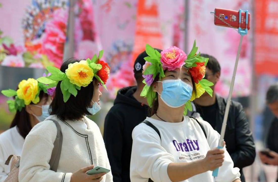 A woman takes a selfie at a peony garden in Heze City, east China's Shandong Province, April 8, 2021. Heze was named by the China Flower Association as capital of peony in China in 2012. (Xinhua/Li He)