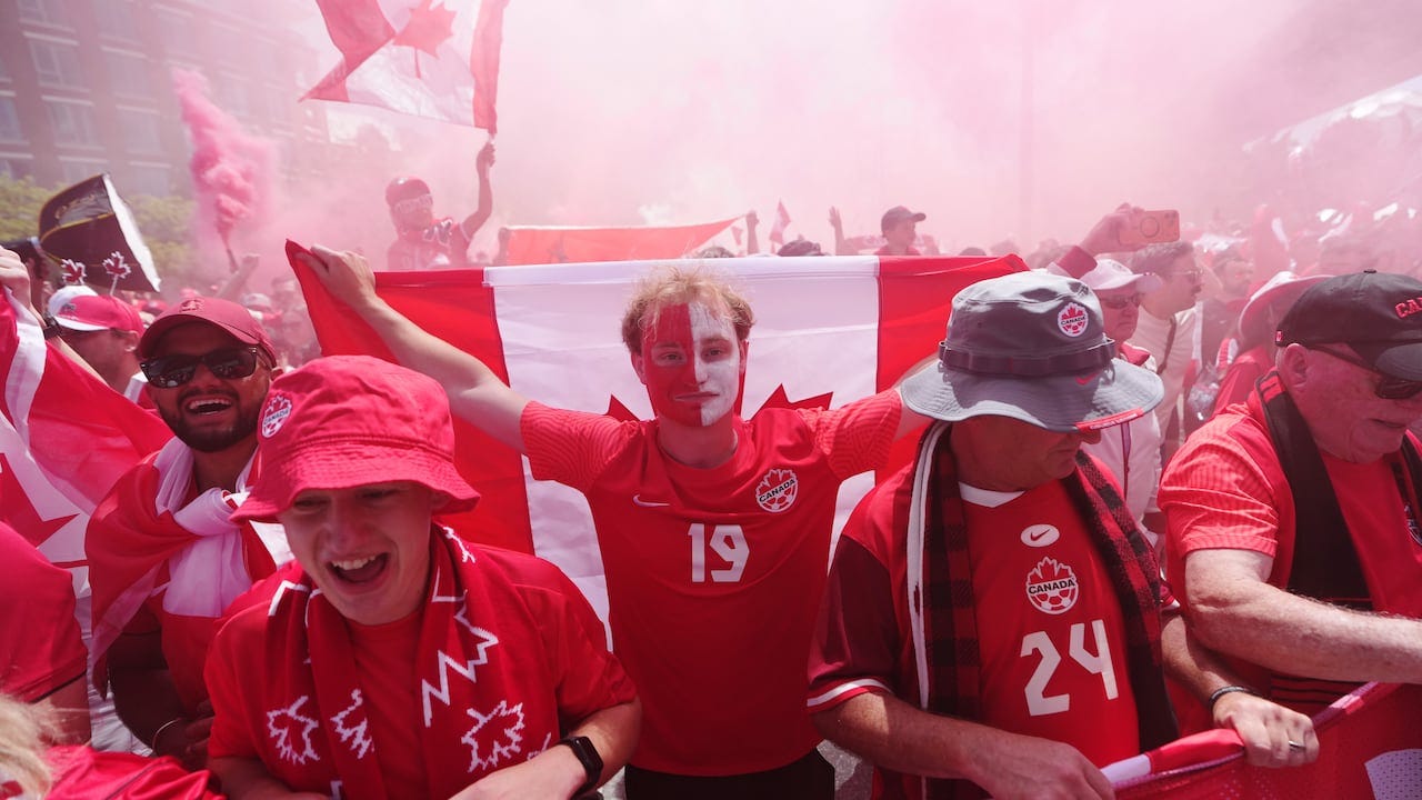 People dressed in red and white as red smoke billows behind them
