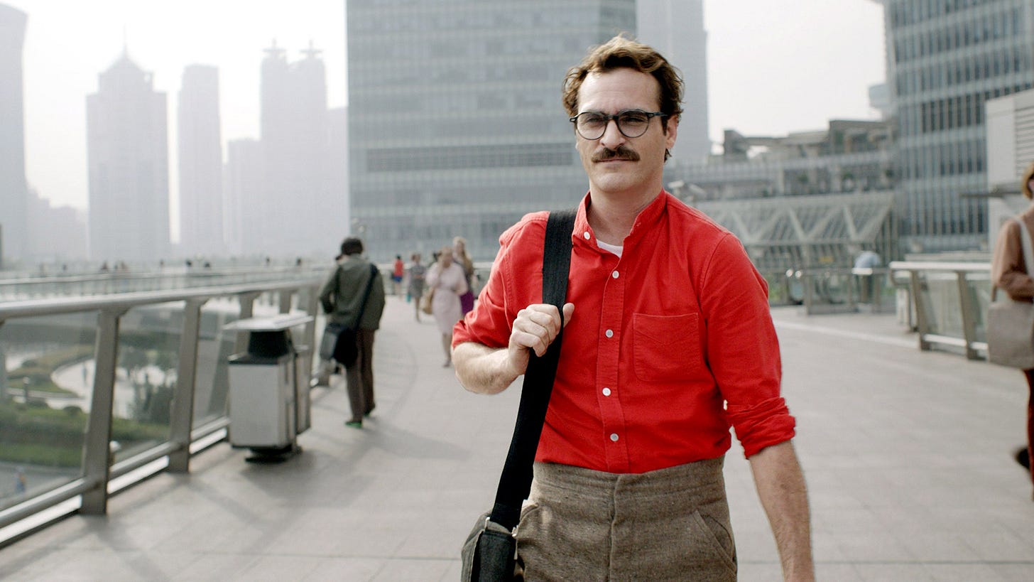 Person wearing a red buttondown shirt walking on a wide sidewalk in a city
