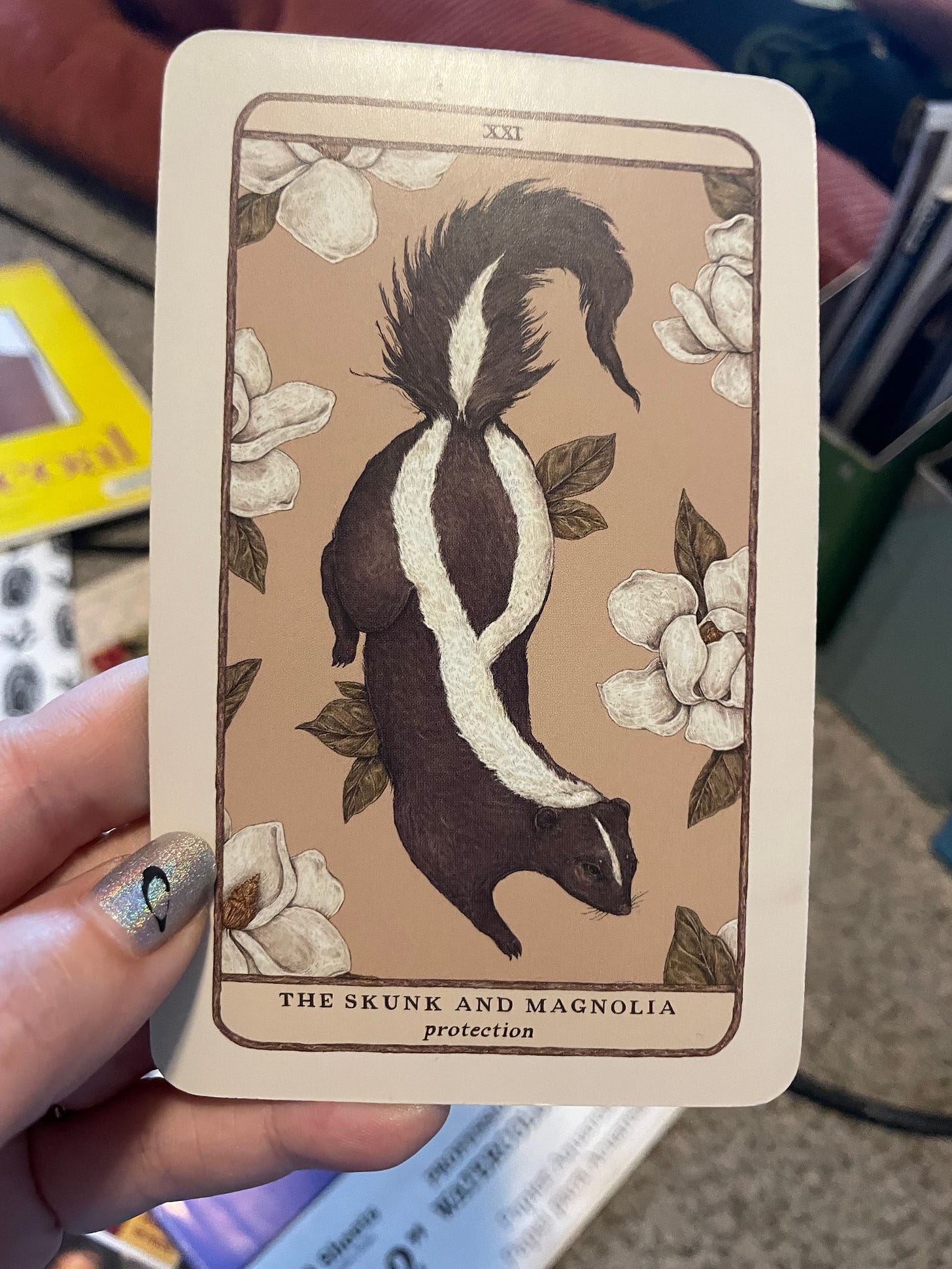 a card with an illustration of a skunk and magnolia flowers that says protection